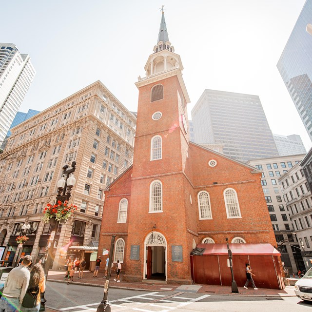 Brick two story building with a brick steeple in the center-front of the building.