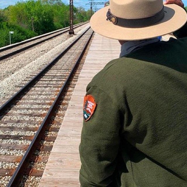 Park ranger next to train tracks
